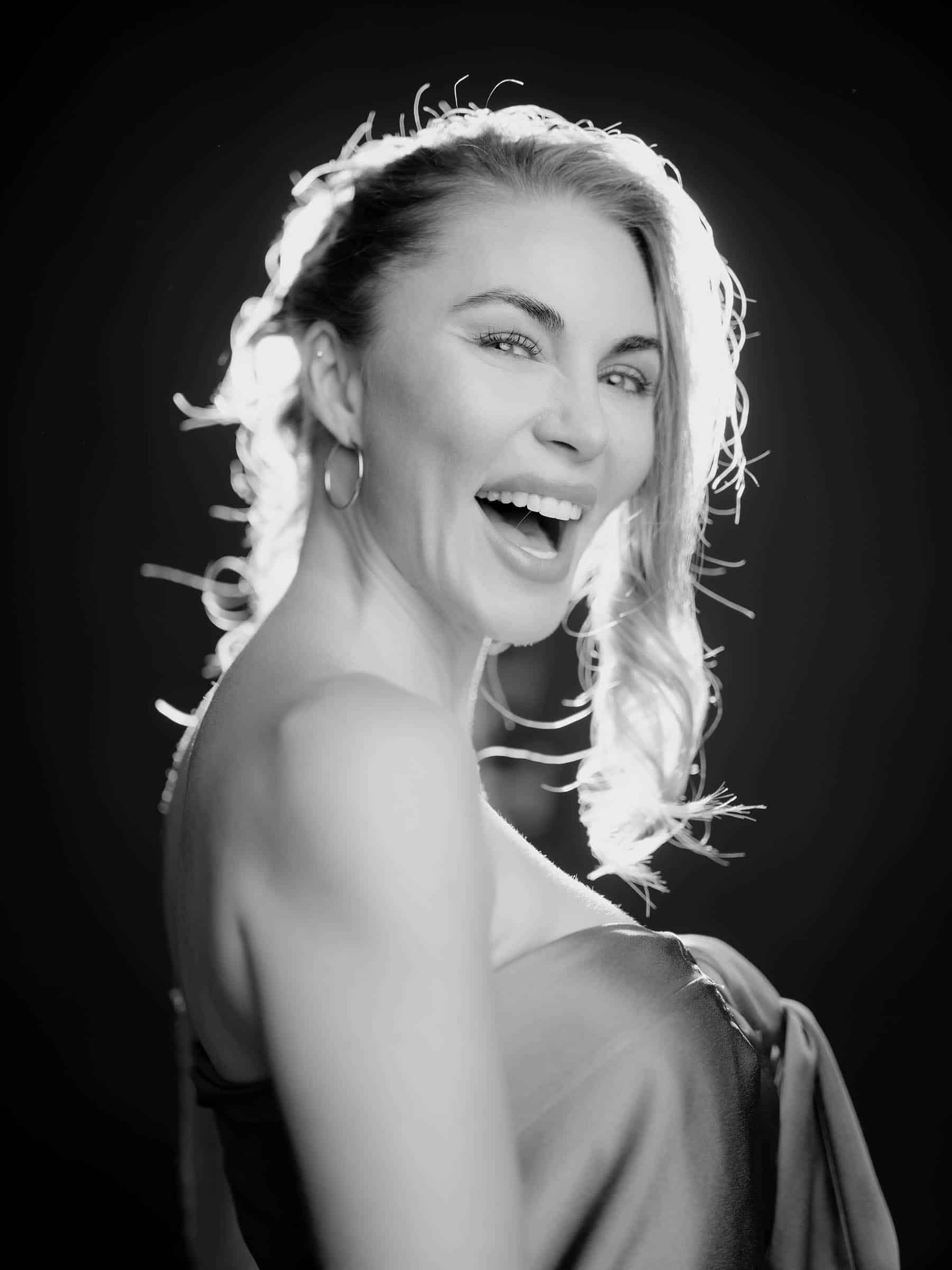 Woman laughing joyfully with radiant skin, representing natural anti-aging results