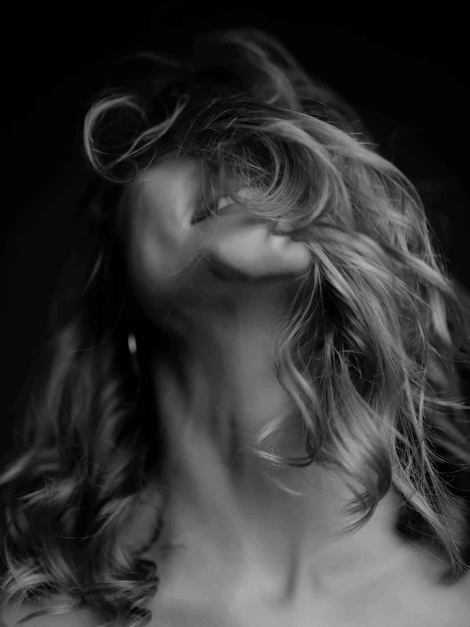 Woman with flowing hair in motion, artistic black and white beauty portrait