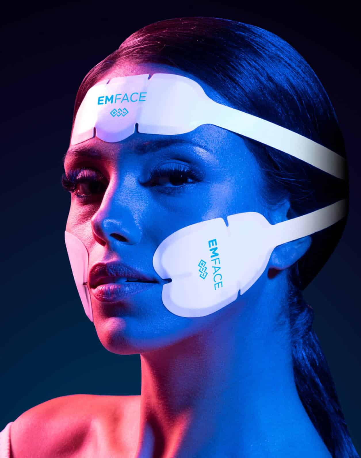 Patient wearing EMFACE facial toning device with electrode pads during treatment