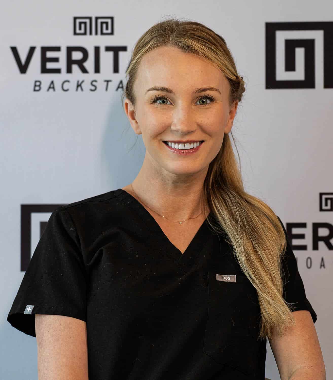 Mackenzie Cunningham, RN at Veritas Backstage, wearing medical scrubs
