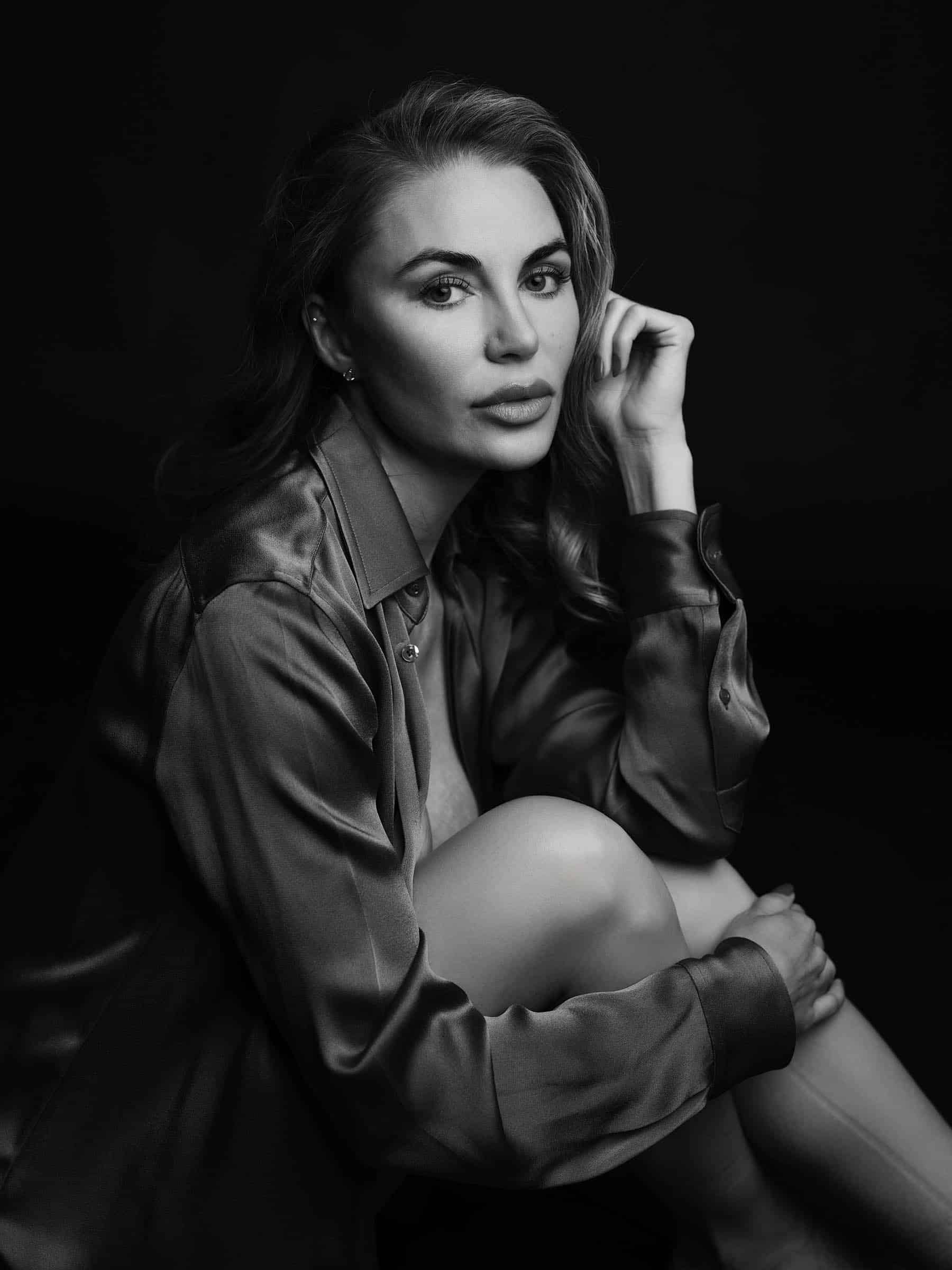 Woman in satin blouse with radiant skin, black and white beauty portrait